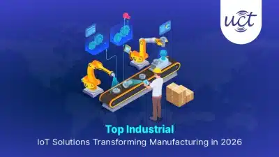 Technician using a tablet to monitor robotic arms and assembly line data, highlighting key industrial IoT solutions in manufacturing.